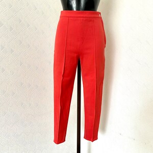 May include: A pair of coral red cropped pants with a high waist and a straight leg.