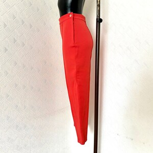 May include: A red pencil skirt with a single button closure at the waist.