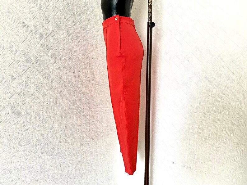 May include: A red pencil skirt with a single button closure at the waist.
