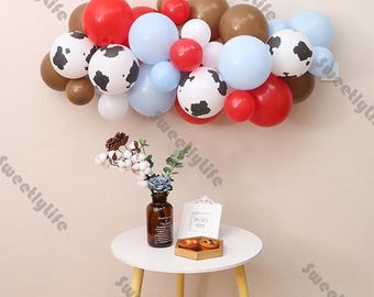 Guirnalda de 40 globos con temática de vaca en colores blanco, rojo, azul y caramelo. Ideal para baby showers, cumpleaños, bodas, despedidas de soltera y fiestas de revelación de género.
