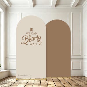 Puede incluir: Dos paneles de fondo arqueados con una base de marco de metal dorado. El panel izquierdo es beige con un icono de oso marrón, una huella y el texto WE CAN Bearly WAIT. El panel derecho es marrón sólido. El texto SweetlyLife aparece abajo a la izquierda.