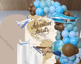 Könnte beinhalten: Ein brauner und blauer Ballonbogen mit weißen Punkten, eine Weltkarten-Kulisse und der Text "Adventure Awaits". Es gibt zwei Spielzeugflugzeuge und einen Globusballon.