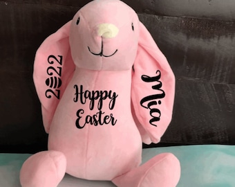 May include: Pink plush bunny rabbit with embroidered text "Happy Easter" and "Mia 2022" on the ears.