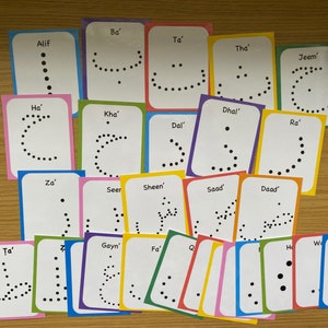 Peut inclure: Un ensemble de 20 cartes m&eacute;moire color&eacute;es avec des points noirs dispos&eacute;s en forme d'alphabet arabe. Chaque carte porte le nom de la lettre &eacute;crit en anglais.