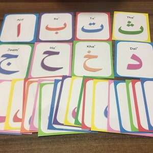May include: A set of colorful flashcards featuring the Arabic alphabet. Each card has a different letter with its name written in English. The letters are written in a stylized font and are surrounded by a colorful border.