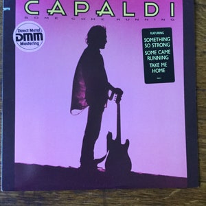 May include: A pink and black album cover with the title "CAPALDI SOME COME RUNNING" and a silhouette of a person holding a guitar. The album features the songs "SOMETHING SO STRONG", "SOME CAME RUNNING", "TAKE ME HOME".