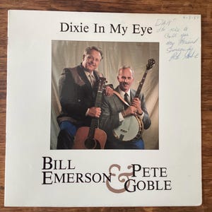 May include: A vintage record album cover featuring two men holding musical instruments. The album is titled "Dixie In My Eye" and features the names "Bill Emerson & Pete Goble".