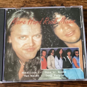 May include: A CD case with a red and white title "More Hard Rock Mixes". The front cover features a photo of Metallica's James Hetfield and Guns N' Roses' Axl Rose. The back cover features a group photo of Guns N' Roses, Van Halen, and Deep Purple.