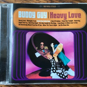 May include: A CD cover featuring Buddy Guy, a blues musician, sitting in a black and white polka dot chair. The album cover is for the album "Heavy Love" and features the text "Heavy Love - Midnight Train featuring Jonny Lang - I Got A Problem - I Need You Tonight - Saturday Night Fish Fry - Had A Bad Night - Are You Lonely For Me Baby - I Just Want To Make Love To You - Did Somebody Make A Fool Out Of You - When The Time Is Right - Let Me Show You".