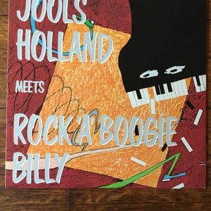 May include: A colorful album cover with a piano and the text "Jools Holland meets Rocka Boogie Billy" in white lettering.