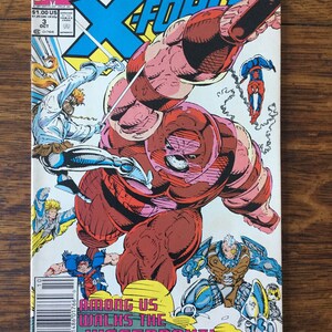 May include: A comic book cover featuring the X-Force team battling the Juggernaut. The cover is red, yellow, blue, and white with the words "Among Us Walks The Juggernaut!" printed on the bottom.
