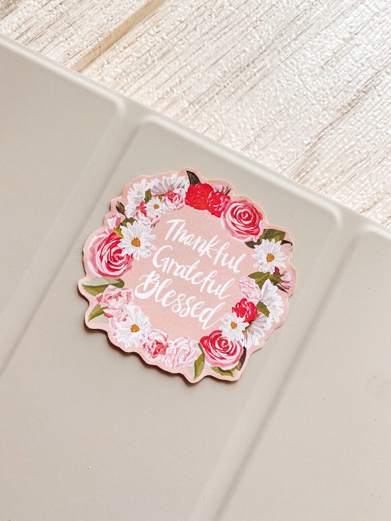 May include: Pink floral sticker with the text "Thankful Grateful Blessed" in white cursive lettering.