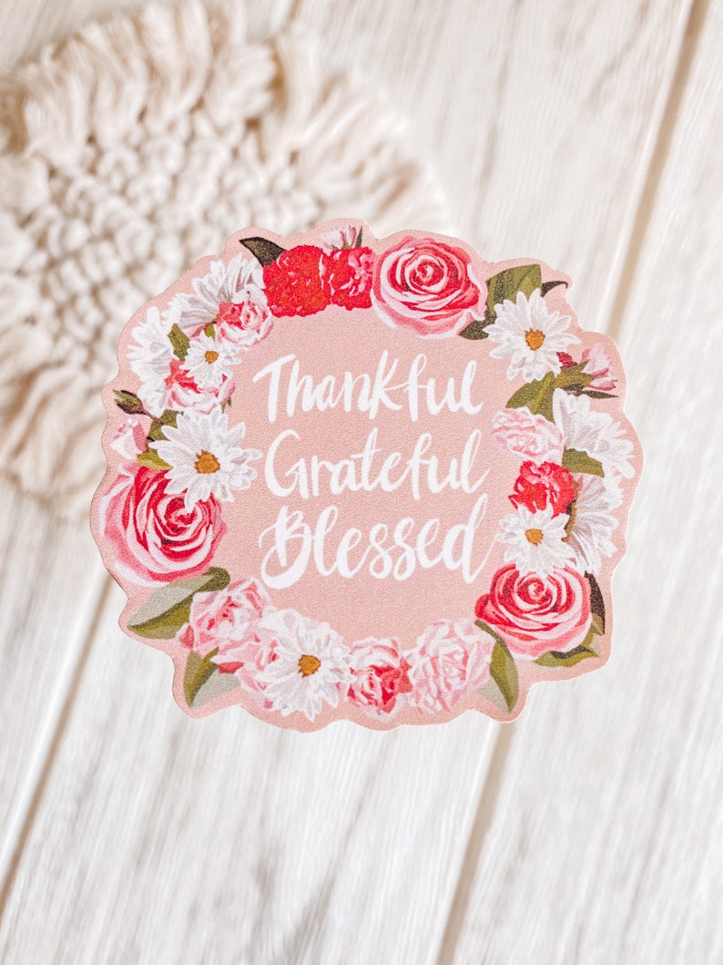 May include: Pink floral wreath sticker with the text "Thankful Grateful Blessed" in white cursive lettering.