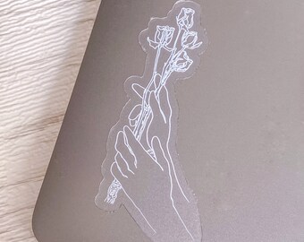May include: A clear sticker with a white outline of a hand holding a bouquet of roses.