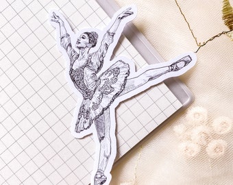 May include: A black and white line drawing of a ballerina in a tutu, with her leg extended in a graceful pose. The drawing is on a piece of paper with a grid pattern.