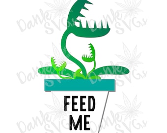 Puede incluir: Una planta verde y blanca con una gran boca y el texto "FEED ME" en la maceta. La planta está en una maceta turquesa.