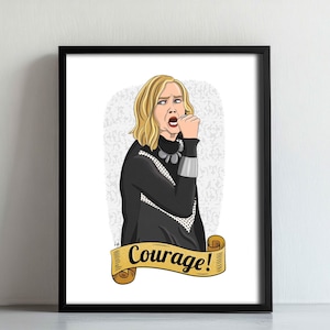 May include: Framed art print featuring a cartoon illustration of a woman with blonde hair, wearing a black outfit with silver accents. The print includes the word "Courage!" on a banner.