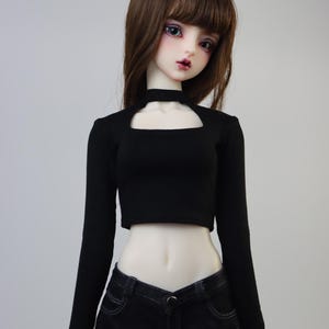 May include: A black long-sleeved crop top with a cutout neckline and black denim shorts.