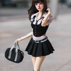 May include: A doll dressed in a school uniform, featuring a black pleated skirt, a black vest over a white collared shirt, and a black tie. The doll carries a black bag with gray straps and wears black boots.