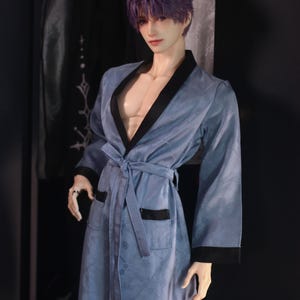 May include: A blue robe with a black trim and a tie belt. The robe has a floral pattern and is made of a soft, comfortable fabric.