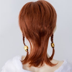 May include: A long, straight, auburn-colored wig with two braids tied with gold beads.