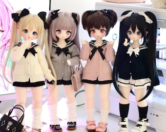 May include: Four dolls with long black hair, wearing sailor collars and sweaters, stand on a table with a pink keyboard and mouse. The dolls are wearing different coloured sweaters: white, grey, pink, and black.