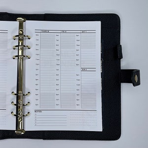 Puede incluir: Una agenda encuadernada en cuero negro con anillas doradas y una disposición semanal. La agenda tiene secciones para jueves, viernes, sábado y domingo. La agenda tiene una sección de notas en la parte inferior.