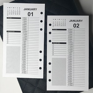 Puede incluir: Una agenda diaria en blanco y negro con un calendario para enero. La agenda tiene una lista de tareas pendientes y una sección para prioridades. La agenda está diseñada para el 1 y el 2 de enero.