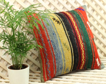 May include: A colorful striped throw pillow with a woven pattern in shades of red, yellow, blue, green, and black. The pillow is made of a soft, textured fabric and is perfect for adding a touch of bohemian style to any room.