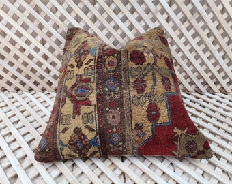 May include: A decorative pillow with a vintage, hand-woven design featuring a red, brown, and beige color scheme. The pillow has a traditional, geometric pattern with floral motifs.