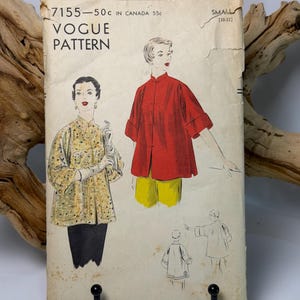 May include: A vintage Vogue Pattern 7155 sewing envelope for a jacket, size small 30-32. The cover features illustrations of two jacket variations: one in a yellow floral print and one in solid red, both with mandarin collars and toggle closures.