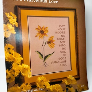 May include: A cross-stitch pattern leaflet titled God's Marvelous Love, Leaflet #5, featuring a framed design of two yellow flowers with the text: May your roots go down deep into the soil of God's marvelous love. The cover shows yellow flowers.