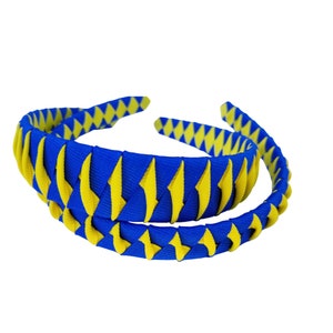 May include: A blue and yellow headband with a braided design. The headband is made of fabric and is suitable for women and girls.