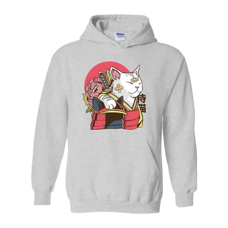 Peut inclure: Un sweat-shirt gris avec un chat blanc portant une armure de samoura&iuml; rouge et or et tenant une &eacute;p&eacute;e. Le chat a un bandage sur l'&oelig;il et un cercle rouge avec une fleur rose derri&egrave;re lui. Le mot japonais "侍猫" est &eacute;crit sur le sweat-shirt.