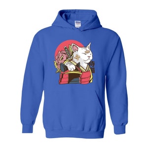 Peut inclure: Un sweat-shirt bleu avec un chat blanc portant une armure de samoura&iuml; rouge et or et tenant une &eacute;p&eacute;e. Le chat a un bandage sur l'&oelig;il et le texte "Lucky Cat" en japonais est imprim&eacute; sur le sweat-shirt.