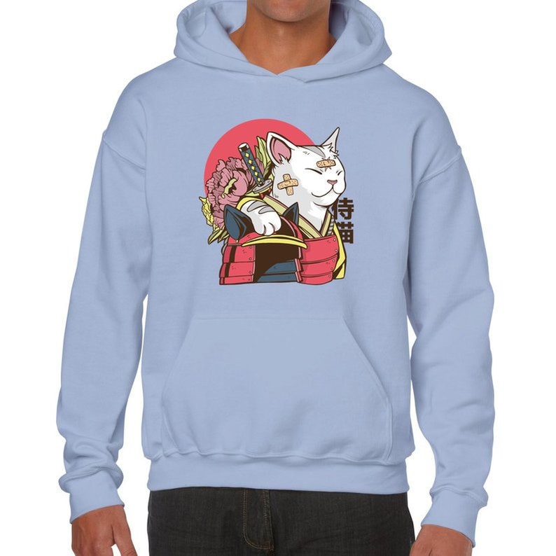 Peut inclure: Un sweat-shirt bleu clair avec un motif repr&eacute;sentant un chat blanc portant une armure de samoura&iuml; et tenant un katana. Le chat a des bandages sur le visage et est entour&eacute; d'un cercle rouge et de fleurs roses. Le mot japonais "侍猫" est imprim&eacute; sur le sweat-shirt.