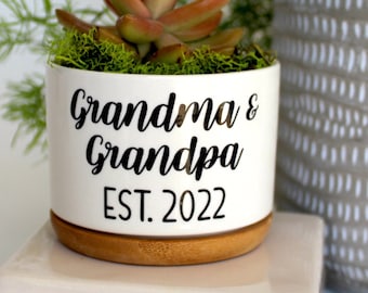 May include: A set of three ceramic mugs with a speckled, matte finish. The mugs are in shades of cream, light gray, and dark gray. Each mug has a simple, minimalist design and a rounded handle.