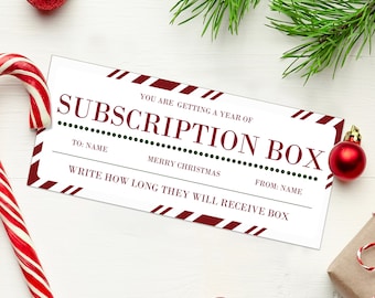 May include: A white gift card with red and white stripes on the border. The text on the card reads "You are getting a year of Subscription Box. To: Name Merry Christmas From: Name Write how long they will receive box".