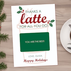 May include: A white card with a red and green coffee cup design. The text on the card reads "Thanks a latte for all you do!" and "You are the best!" with a green gift card area. The card is signed "Love, Olivia" and "Happy Holidays".