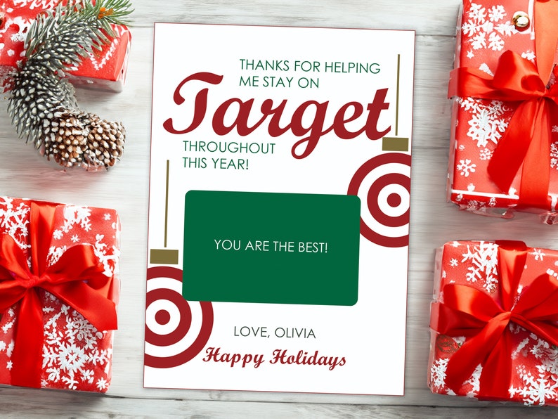 May include: A white card with red and gold accents featuring a red target graphic and the text "Thanks for helping me stay on Target throughout this year! You are the best! Love, Olivia Happy Holidays".