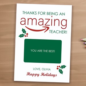 May include: A white card with a green and red holly design. The card says "Thanks for being an amazing teacher!" and "You are the best!" with a space for a gift card. The card also says "Love, Olivia" and "Happy Holidays".