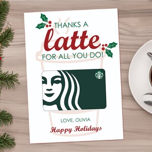 May include: A white card with a red and green illustration of a coffee cup and the text "Thanks a latte for all you do!"  A green Starbucks gift card is in the center of the card. The text "Love, Olivia" and "Happy Holidays" is at the bottom of the card.