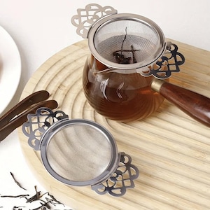 Puede incluir: Un juego de tres tazas de cerámica con un acabado mate moteado. Las tazas son de color crema, gris claro y gris oscuro. Cada taza tiene un diseño simple y minimalista y un asa redondeada.