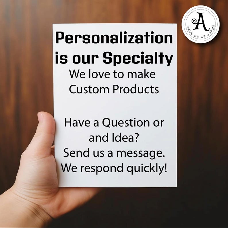 May include: A white card held by a hand with the text "Personalisation is our Speciality" and "We love to make Custom Products". The card also says "Have a Question or and Idea? Send us a message. We respond quickly!"