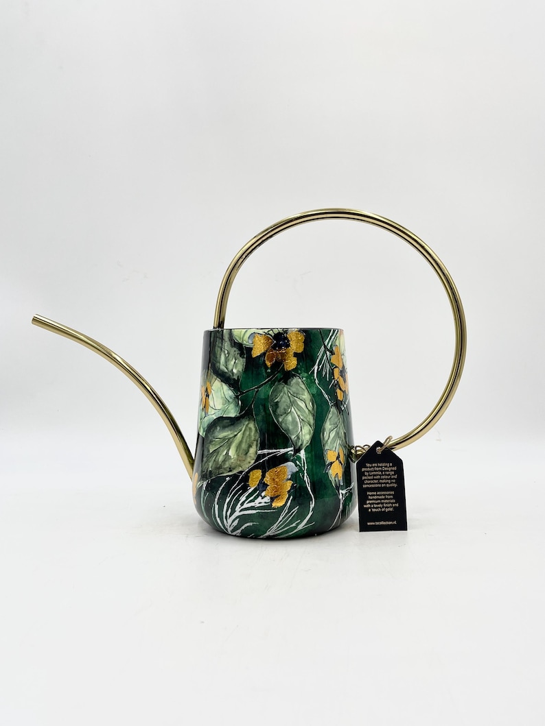 May include: A green watering can with a gold handle and a floral design. The can has a spout and a tag attached to the handle.