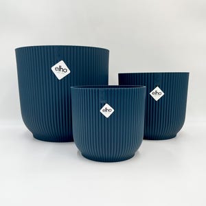 Può includere: Tre vasi per piante in plastica blu con una texture a coste. I vasi hanno la scritta "elho" stampata.