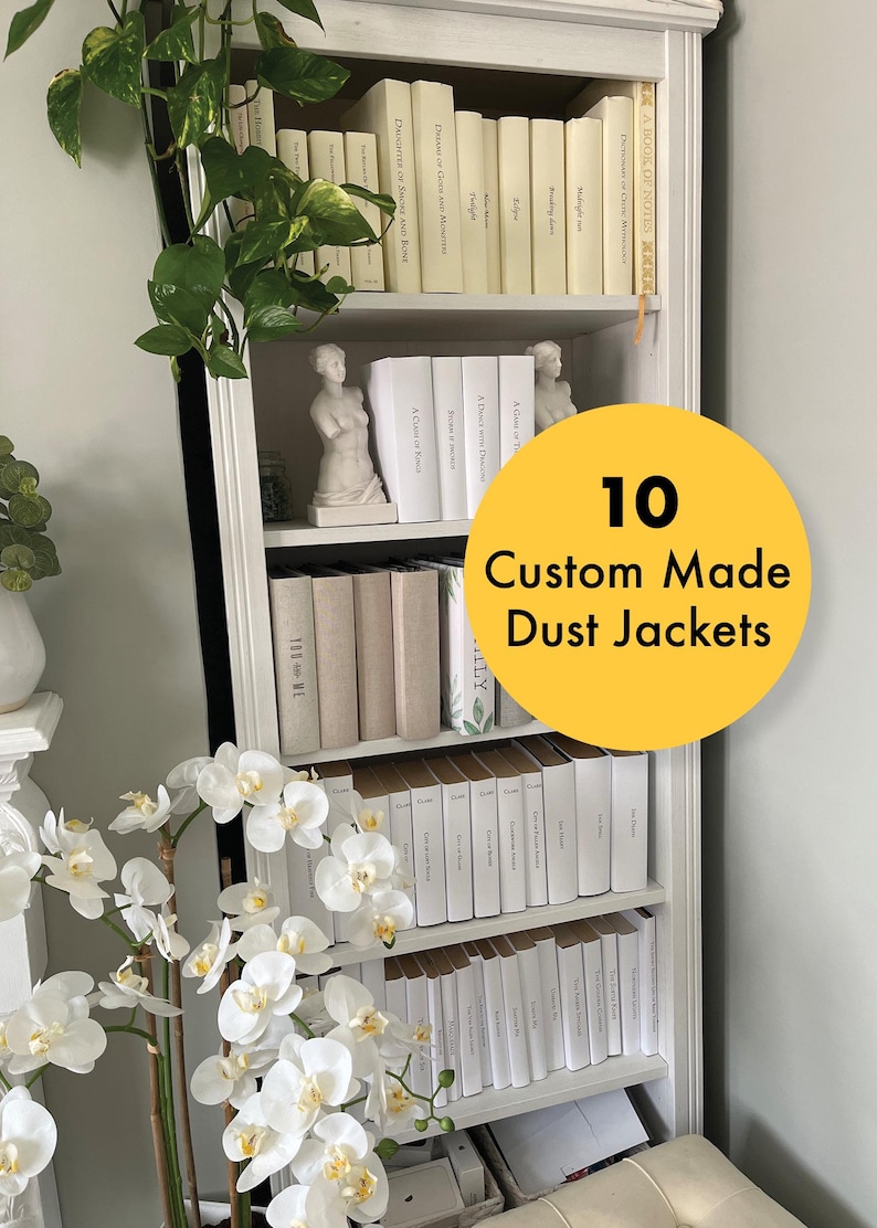 May include: A white bookshelf with 10 custom-made dust jackets for books. The dust jackets are all white with black text. The text on the dust jackets includes "A Gift of Time", "You & Me", "A Place in Time", "A Cure of Peace", "A Necklace of Dreams", "A Gift of Time", "A Cure of Peace", "A Necklace of Dreams", "A Place in Time", and "You & Me".