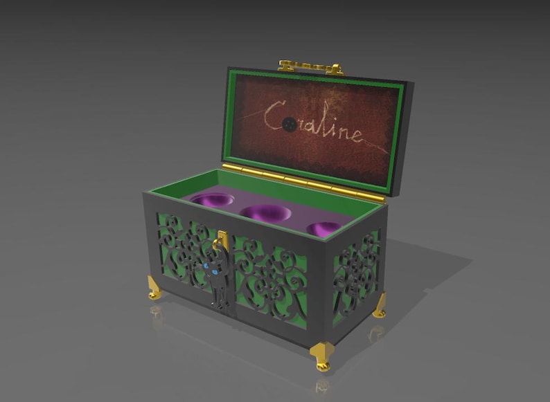 May include: A decorative black chest with green and gold accents, featuring intricate cut-out designs. The interior is green with three purple cup holders. The lid is open, revealing the name "Coraline" in script. The chest has gold feet.
