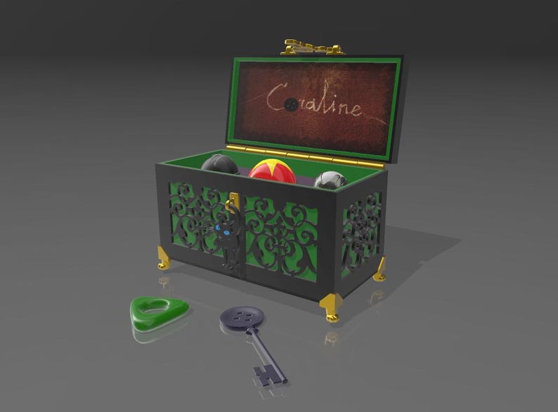May include: A black and green decorative chest with gold accents, open to reveal a red and yellow ball, a gray ball, and a black ball. The chest has a green interior and the name "Coraline" is written on the inside of the lid. A green planchette and a key are in front.