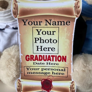 May include: A scroll-shaped graduation sign with spaces for a name, photo, date, and personal message. The sign has a parchment effect and a red wax seal. The word "GRADUATION" is in bold red letters. The sign is a graduation keepsake.